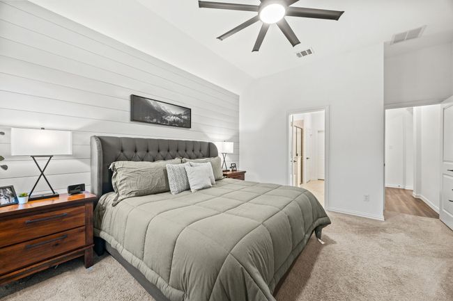 Bedroom featuring light carpet, high vaulted ceiling, baseboards, ceiling fan, and connected bathroom | Image 17