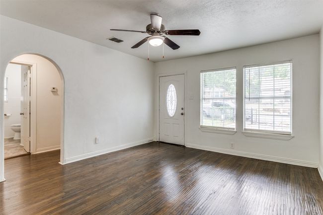Foyer entrance with arched walkways, dark wood-style floors, ceiling fan, and a textured ceiling | Image 7