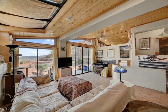 Living area featuring tile patterned floors, wood ceiling, and a ceiling fan | Image 20