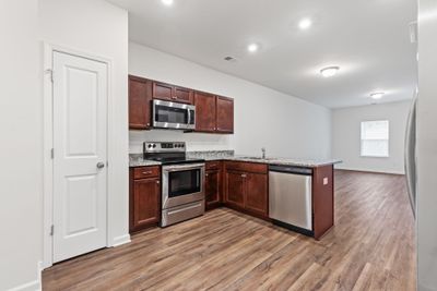 The kitchen combines style and functionality with stainless steel appliances, granite countertops, and a double basin sink, all conveying with the home. 111 Townsend Ave Shelbyville, TN 37160 | Image 2