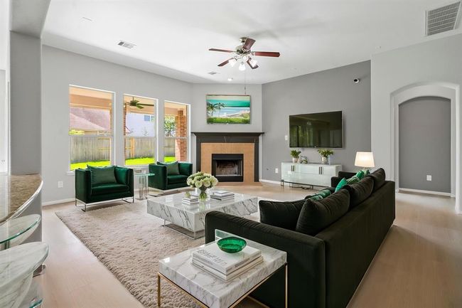 tunning open-concept living room boasts soaring ceilings and an abundance of natural light, creating a bright and airy atmosphere. The seamless flow into the kitchen and dining areas makes it perfect for entertaining or relaxing with family. Featuring expansive windows, elegant finishes, and a spacious layout, this inviting space combines comfort and sophistication in one beautiful setting. | Image 8
