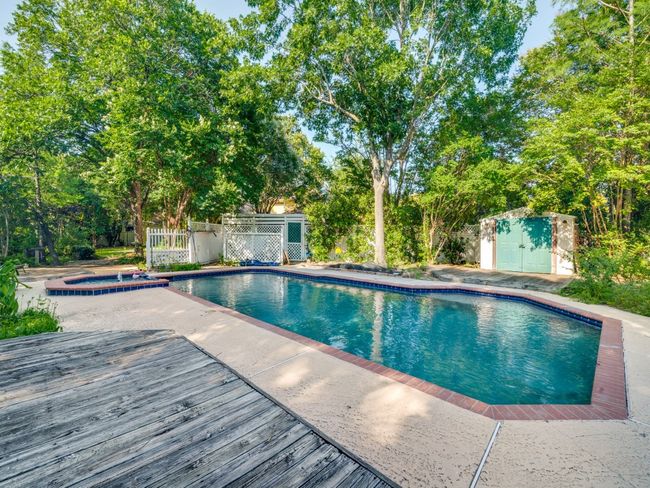 Outdoor pool featuring an in-ground hot tub, view of scattered trees, and a deck | Image 16