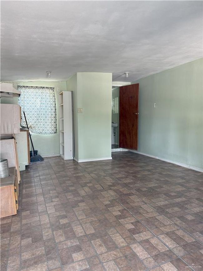 Unfurnished living room featuring baseboards and brick patterned floor | Image 11