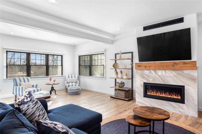 Living room featuring recessed lighting, wood finished floors, a high end fireplace, and baseboards | Image 5