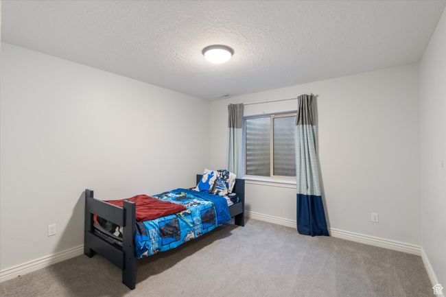 Carpeted bedroom featuring a textured ceiling and baseboards | Image 18