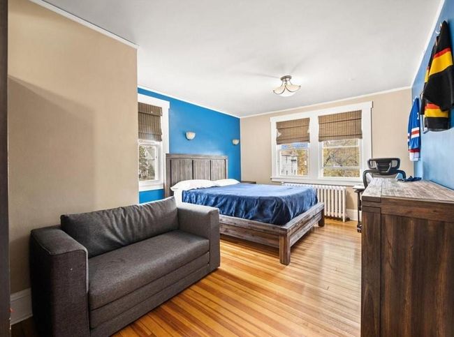Bedroom featuring radiator heating unit and light wood-type flooring | Image 7