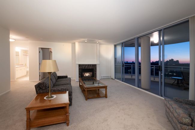 Living area with baseboard heating, a premium fireplace, and carpet | Image 6