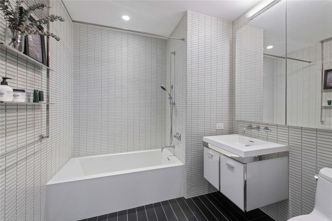 Bathroom featuring vanity, shower combination, tile walls, toilet, and recessed lighting | Image 10