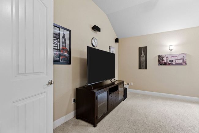 Living area with lofted ceiling, light colored carpet, and baseboards | Image 22