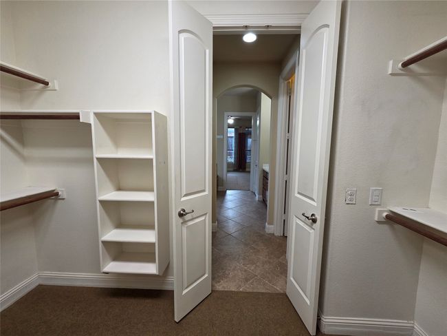 Walk in closet featuring arched walkways and dark tile patterned floors | Image 20