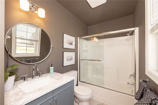 Bathroom with marble finish floor, toilet, vanity, and enclosed tub / shower combo | Image 19