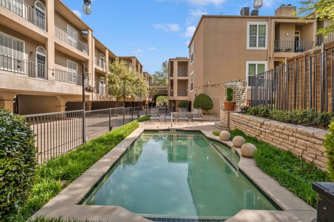 Community pool with fence, a patio area, and a residential view | Image 19