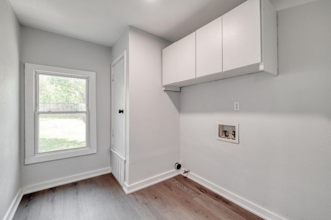 Laundry room featuring hookup for a washing machine, wood finished floors, and cabinet space | Image 15