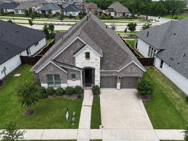 French country style house with brick siding, roof with shingles, a residential view, and concrete driveway | Image 5
