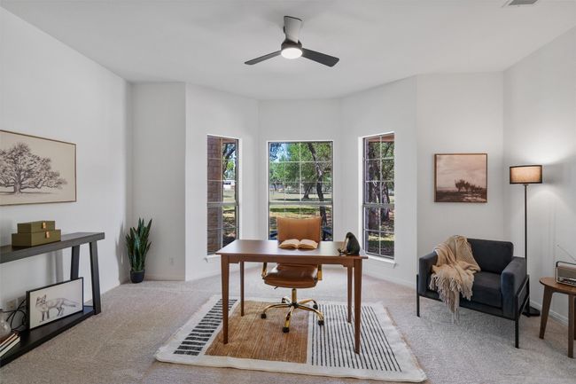 Carpeted office space featuring visible vents, a ceiling fan, and baseboards | Image 9