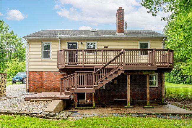 Back of house with a chimney, a deck, stairway, and brick siding | Image 30