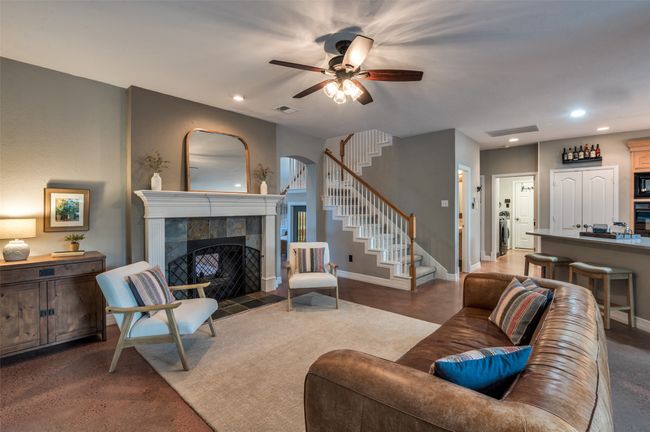 Second living area downstairs w FP and gas logs, view of stairway from this side of the home | Image 12