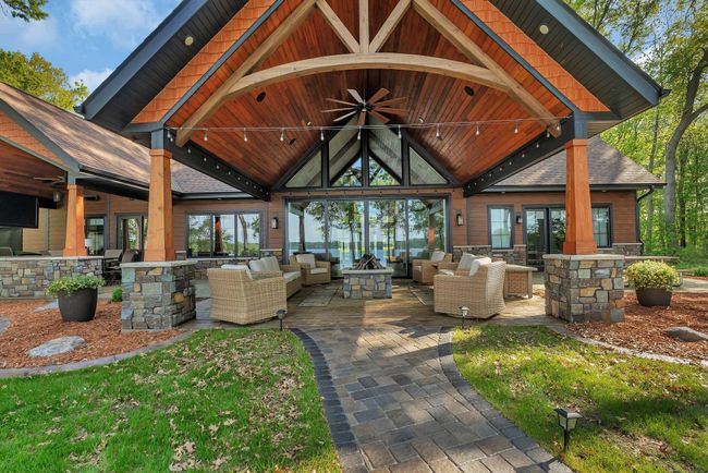 Vaulted, covered sitting area with a gas firepit, built-in speakers, and ambient lighting—perfect for relaxing or entertaining in any season. | Image 4