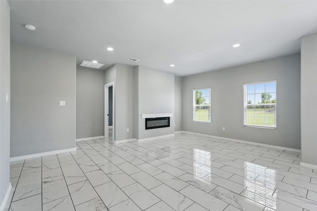 Unfurnished living room with recessed lighting, a glass covered fireplace, and baseboards | Image 11