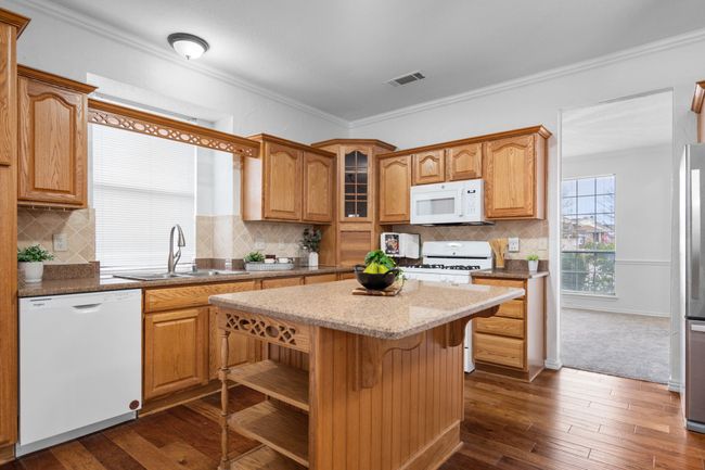 The kitchen has crown molding and an island. | Image 16