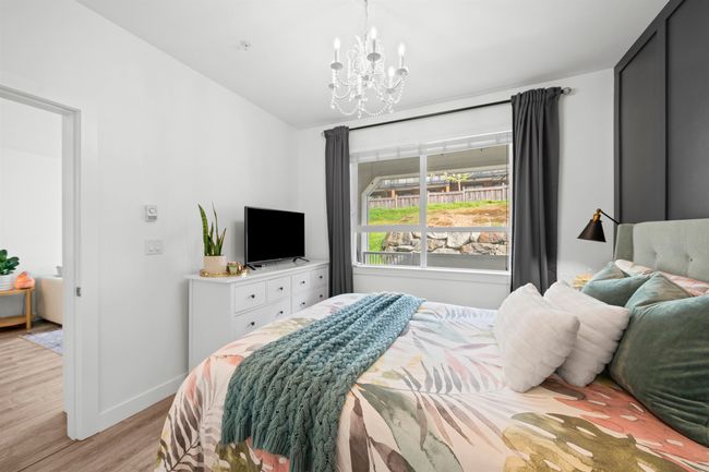 Bedroom featuring baseboards, light wood-style floors, a chandelier, and lofted ceiling | Image 18