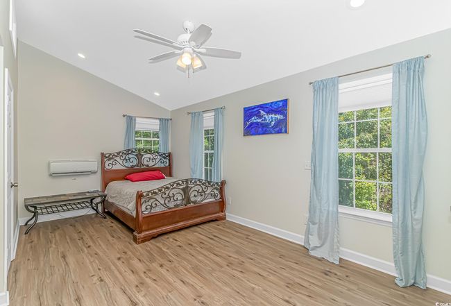 Bedroom featuring light wood finished floors, vaulted ceiling, recessed lighting, and a ceiling fan | Image 24