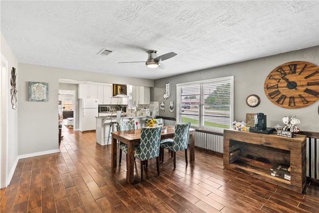 Dining room with dark wood finished floors, ceiling fan, and a textured ceiling | Image 19