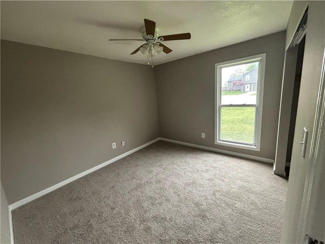 Carpeted empty room featuring a healthy amount of sunlight, ceiling fan, and baseboards | Image 16