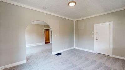 Carpeted room featuring a textured ceiling and ornamental molding | Image 3