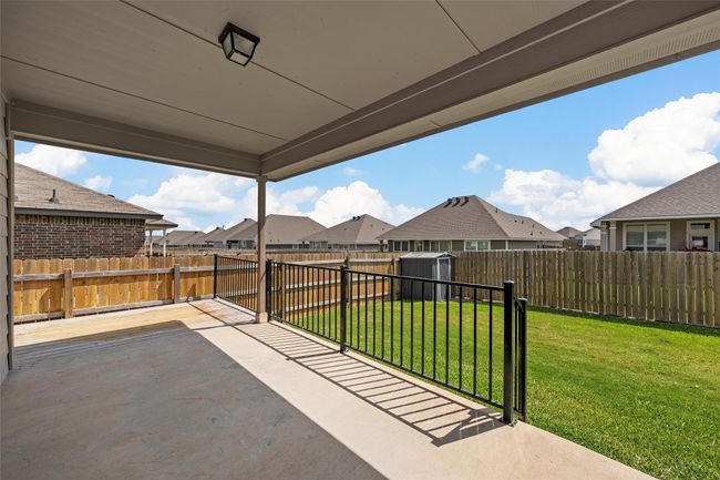 Fenced backyard with a patio, a shed, and a residential view | Image 28