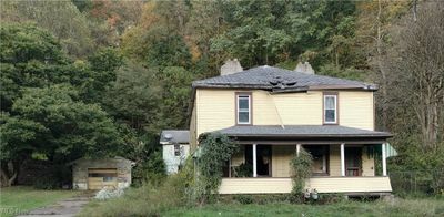 View of front of house featuring an outdoor structure, a garage, and covered porch | Image 1