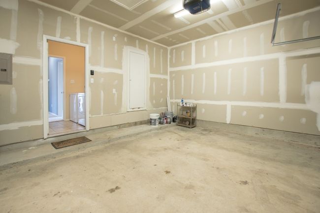 Garage featuring a garage door opener and electric panel | Image 33
