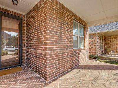 Greet neighbors and guests from the wide front porch accented by herringbone-patterned brick flooring. | Image 2