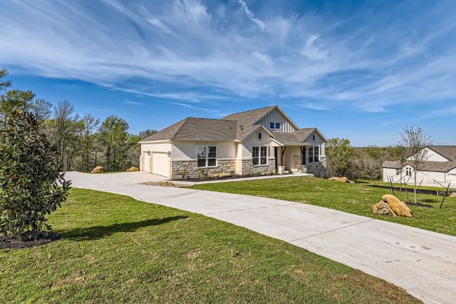 Craftsman-style house with stucco siding, driveway, stone siding, a front yard, and a garage | Image 4