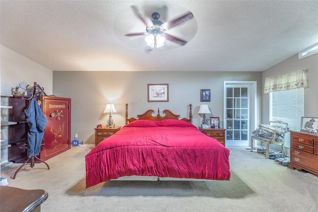 Bedroom with carpet floors, a textured ceiling, and ceiling fan | Image 18