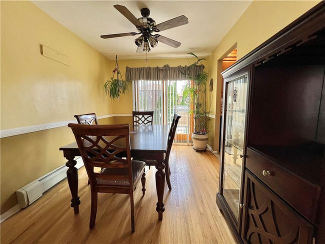 Dining area with ceiling fan, light wood-type flooring, and baseboard heating | Image 6