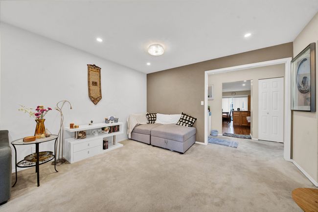 Carpeted living area featuring a tile fireplace and recessed lighting | Image 11