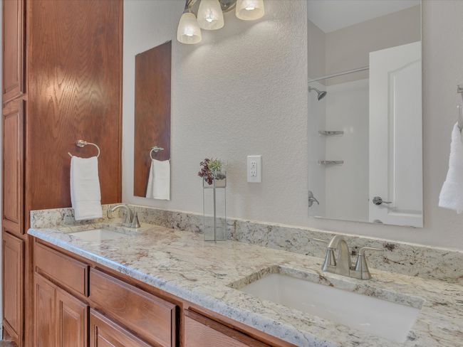 Full bathroom with a shower, double vanity, and a textured wall | Image 26