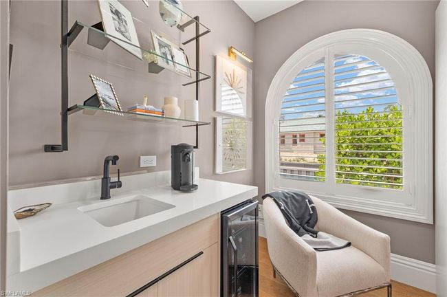 Bar with beverage cooler, light wood-style floors, indoor wet bar, and a sink | Image 27