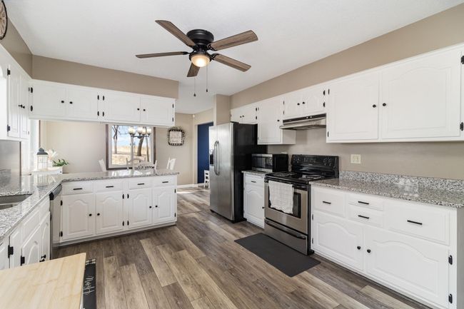 Another view of kitchen into dining area. | Image 8