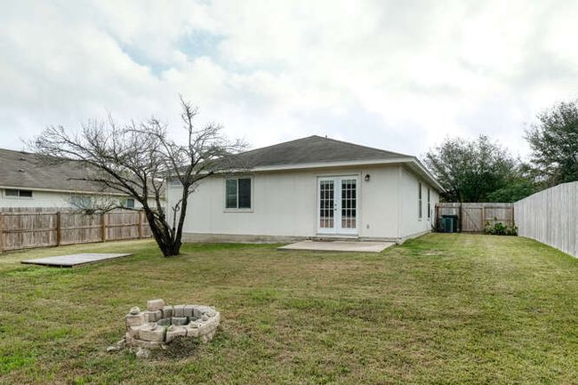 Rear view of property featuring french doors, an outdoor fire pit, cooling unit, and a patio | Image 14