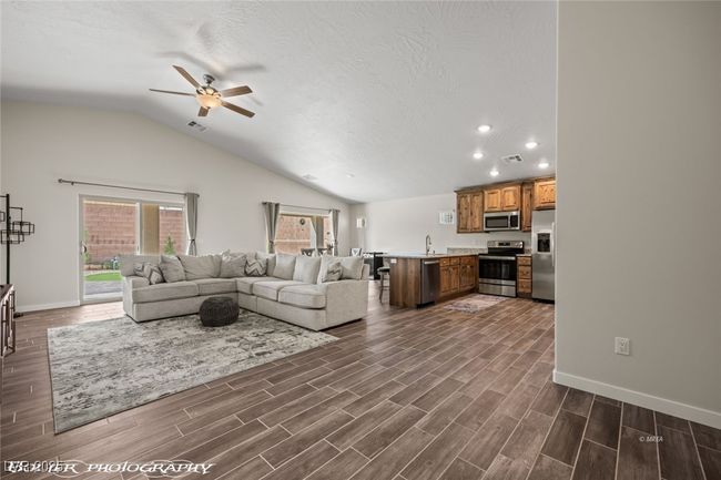 Living area with ceiling fan, recessed lighting, vaulted ceiling, baseboards, and dark wood finished floors | Image 17