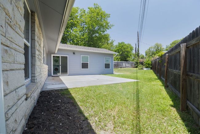Fenced backyard with a patio | Image 33