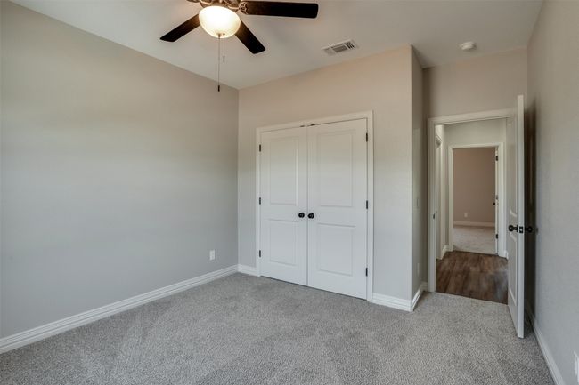 Unfurnished bedroom featuring a ceiling fan, a closet, carpet, baseboards, and visible vents | Image 21