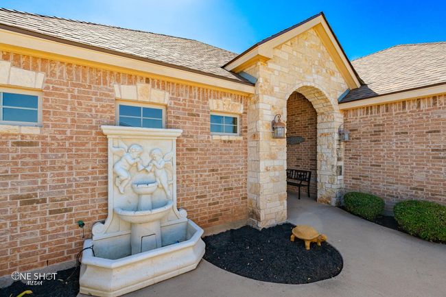 View of exterior entry featuring brick siding and roof with shingles | Image 4