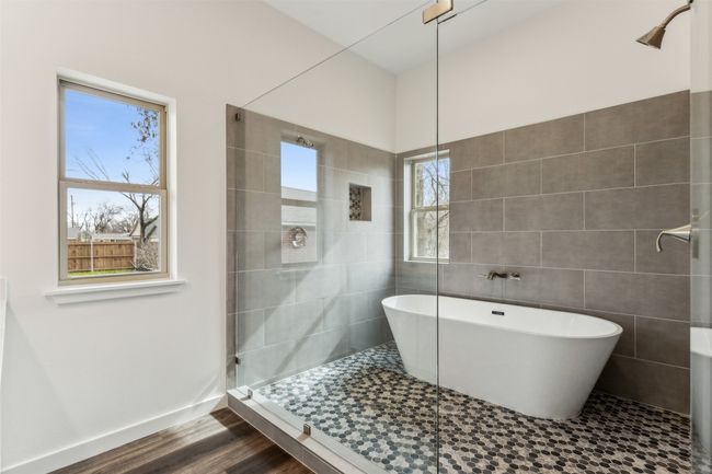 Full bath featuring a soaking tub, plenty of natural light, a stall shower, and tile walls | Image 32