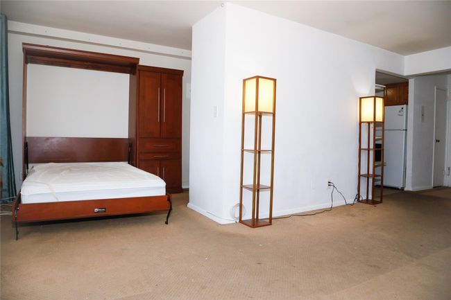 Bedroom with freestanding refrigerator and light carpet | Image 9