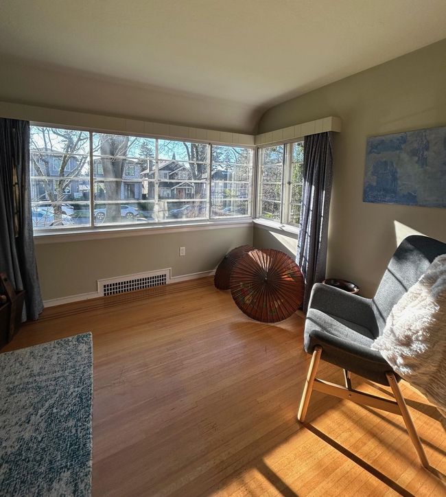 Living area featuring visible vents, wood finished floors, baseboards, and a healthy amount of sunlight | Image 4