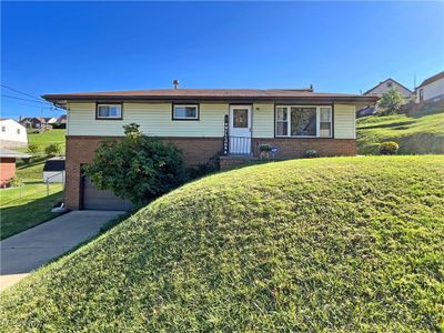 View of front facade with a garage and a front yard | Image 1