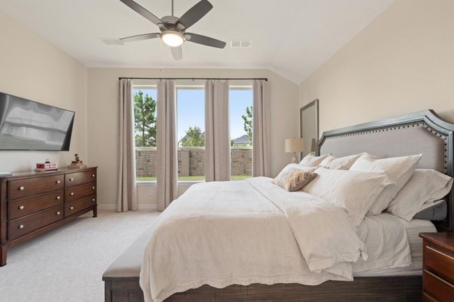 The primary bedroom has luxurious carpet and a wall of windows allowing lots of natural light. | Image 15